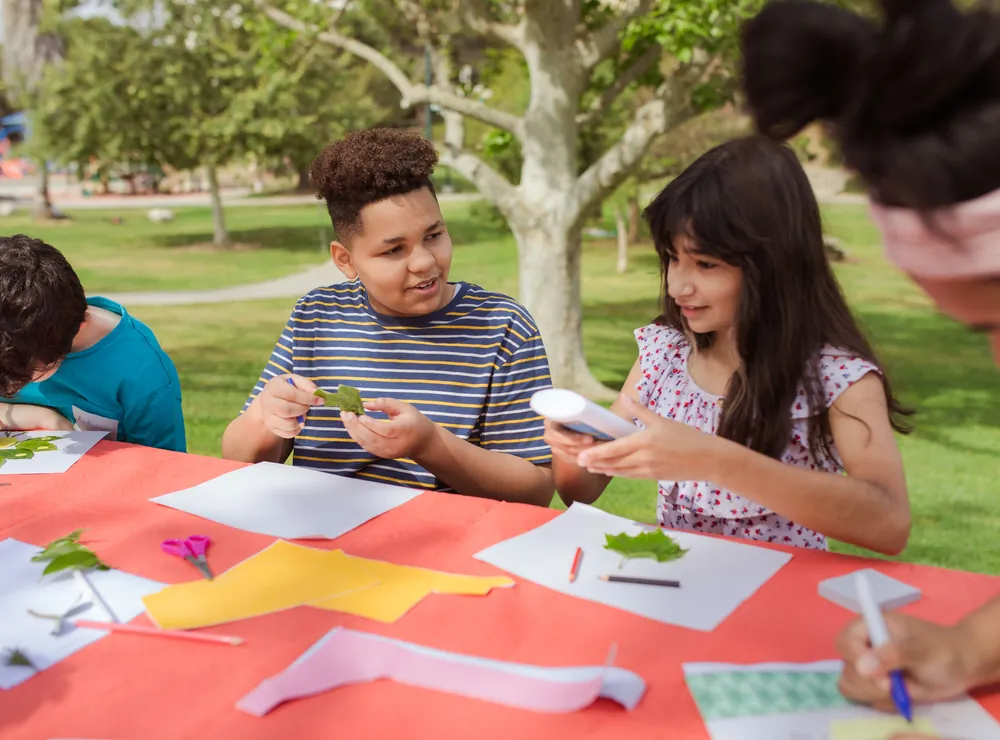 Des enfants composent une mosa&iuml;que de feuilles